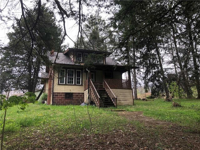 back of house with covered porch and stairway