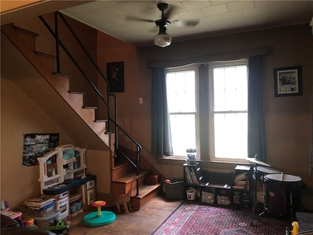 interior space featuring ceiling fan, stairway, and wood finished floors