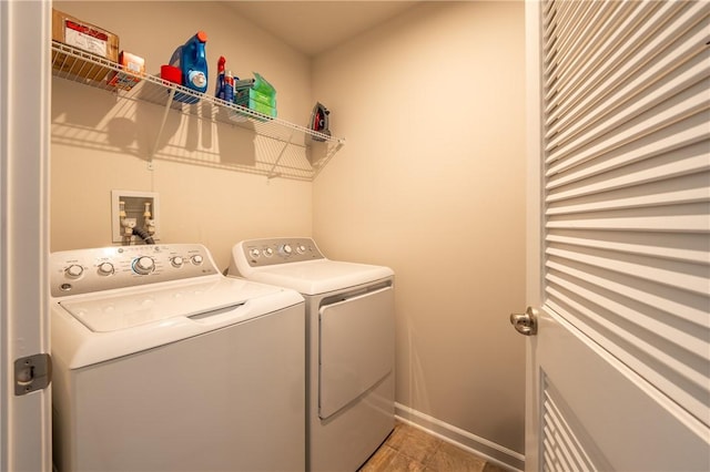 clothes washing area with baseboards, light tile patterned floors, laundry area, and washing machine and dryer