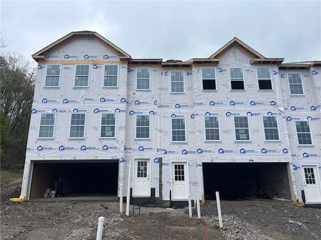 unfinished property featuring a garage and dirt driveway
