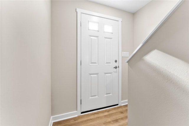 doorway to outside featuring light wood finished floors and baseboards