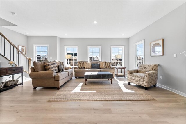 living area with baseboards, recessed lighting, wood finished floors, and stairway
