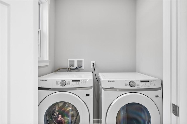 clothes washing area with separate washer and dryer and laundry area