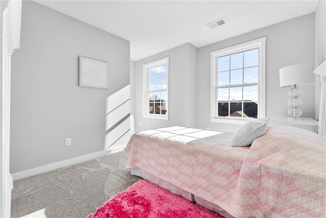 carpeted bedroom with visible vents and baseboards