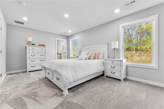 bedroom featuring baseboards, visible vents, and light colored carpet