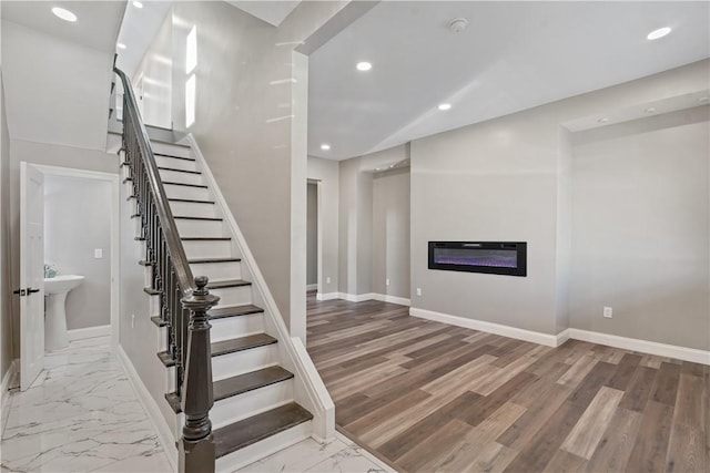 1507 Allegheny Ave, Manchester, PA 15233 - staircase featuring baseboards, recessed lighting, marble finish floor, and a glass covered fireplace
