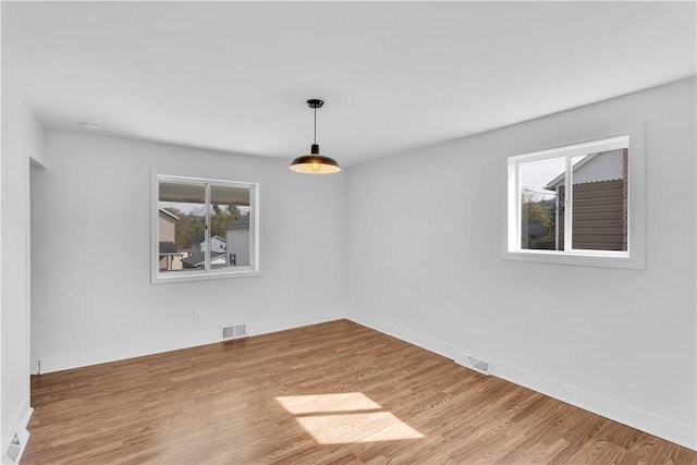 unfurnished dining area with visible vents, wood finished floors, and baseboards