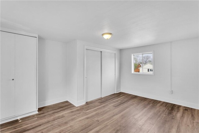 unfurnished bedroom with wood finished floors and baseboards