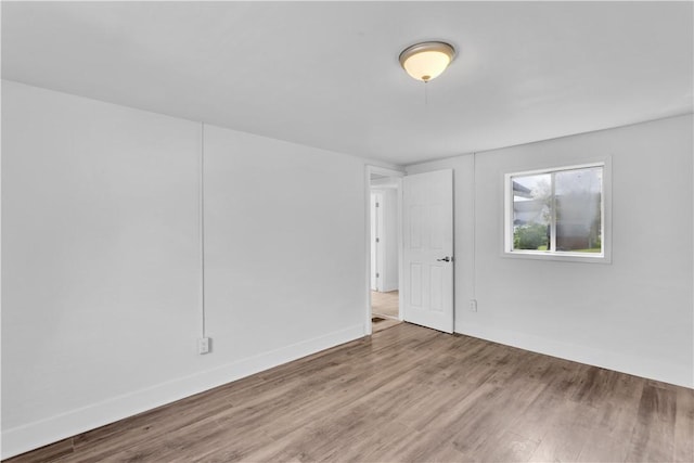 spare room featuring wood finished floors and baseboards