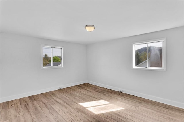 spare room featuring wood finished floors and baseboards