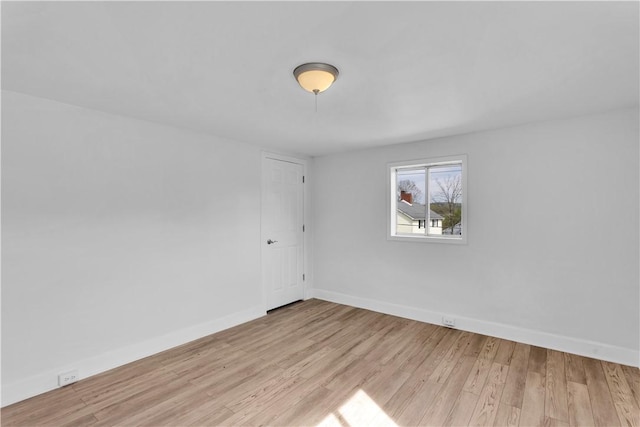 spare room with light wood finished floors and baseboards