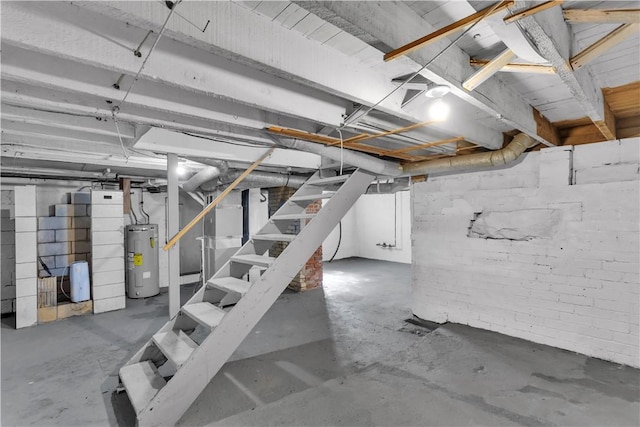unfinished basement with stairway and electric water heater