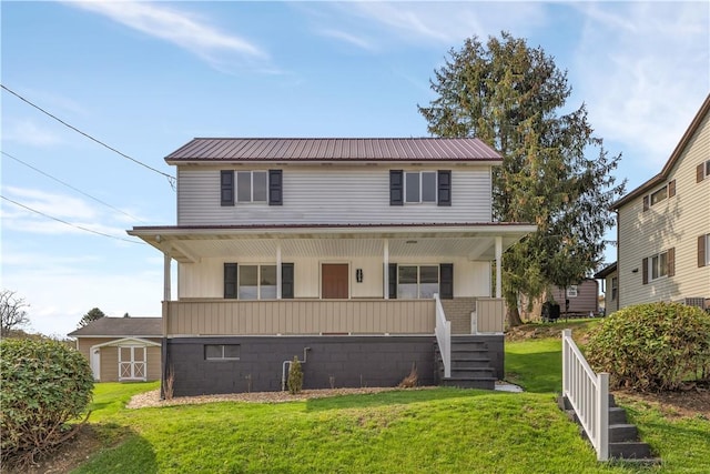 view of front facade with a front yard, metal roof, and a porch