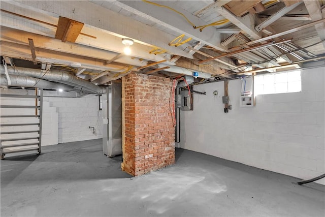 basement featuring concrete block wall and electric panel