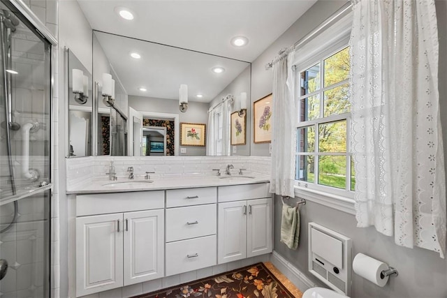 bathroom featuring double vanity, a wealth of natural light, recessed lighting, and a sink