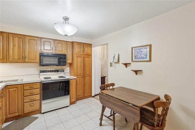 kitchen featuring light tile patterned floors, white range with electric cooktop, light countertops, brown cabinets, and black microwave