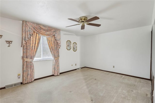 unfurnished room featuring visible vents, a ceiling fan, and carpet flooring