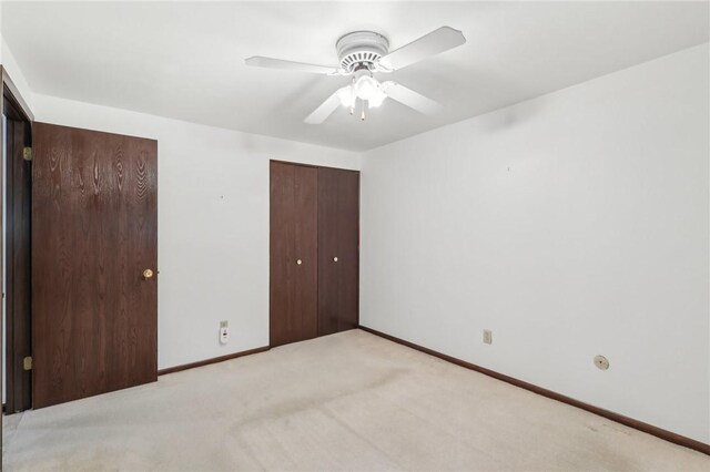 unfurnished bedroom with baseboards, light carpet, and ceiling fan