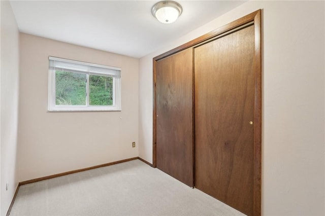 unfurnished bedroom featuring a closet, carpet floors, and baseboards