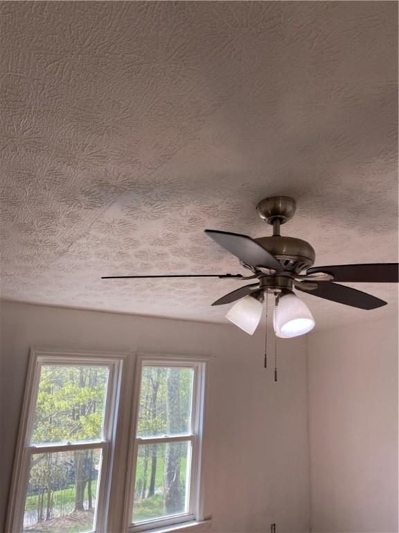 interior details with a ceiling fan and a textured ceiling