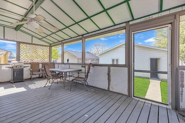 sunroom featuring outdoor dining space and a ceiling fan