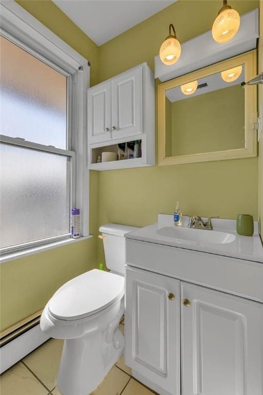 half bath with a baseboard heating unit, toilet, tile patterned flooring, and vanity