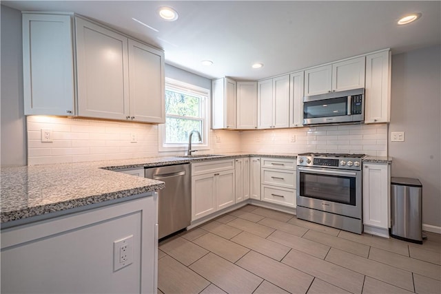 215 Wyngate Rd, Moon/Crescent Twp, PA 15108 - kitchen featuring white cabinetry, a sink, appliances with stainless steel finishes, light stone countertops, and backsplash