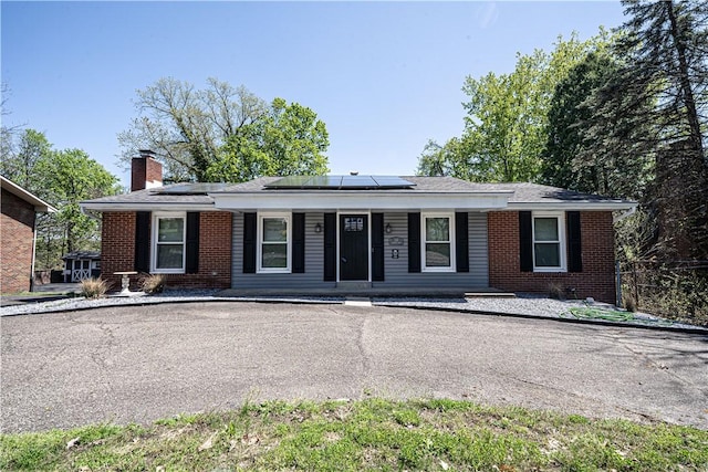 215 Wyngate Rd, Moon/Crescent Twp, PA 15108 - single story home with a chimney, brick siding, a porch, and solar panels