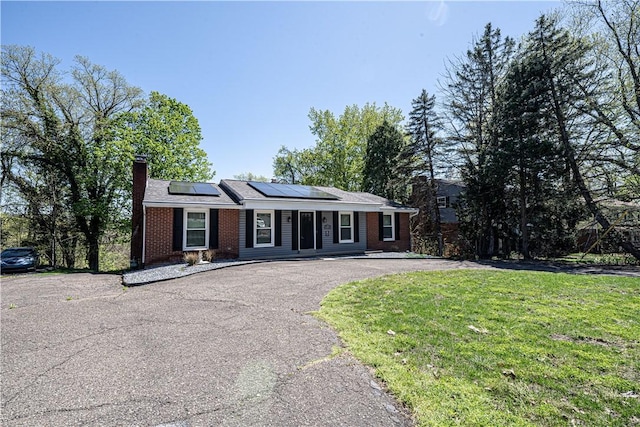 215 Wyngate Rd, Moon/Crescent Twp, PA 15108 - ranch-style house with a chimney, brick siding, aphalt driveway, solar panels, and a front yard