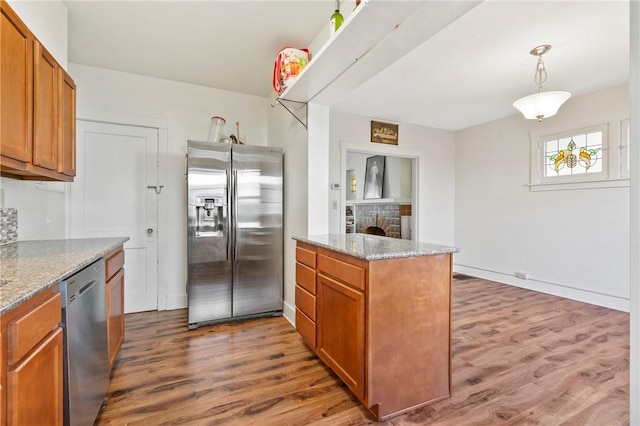 1163 Chislett, Morningside, PA 15206 - kitchen featuring brown cabinetry, light stone counters, appliances with stainless steel finishes, and wood finished floors