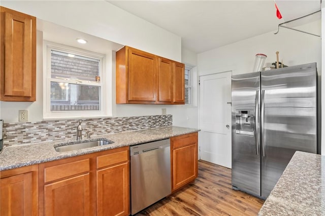 1163 Chislett, Morningside, PA 15206 - kitchen featuring tasteful backsplash, brown cabinetry, stainless steel appliances, a sink, and light wood-type flooring