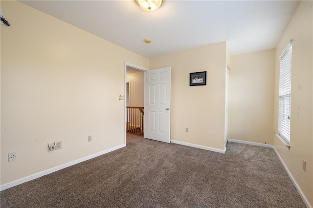 unfurnished bedroom with carpet, baseboards, and multiple windows