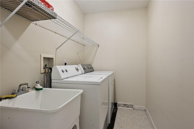 laundry room with laundry area, washer and dryer, a sink, baseboards, and visible vents
