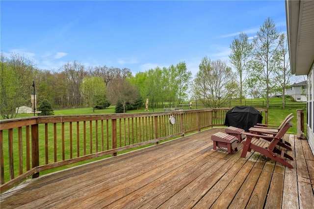 wooden deck with a grill and a lawn