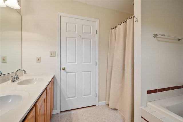 bathroom with tile patterned flooring, a sink, double vanity, and a bathing tub