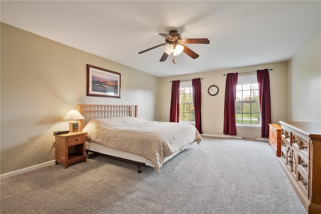 carpeted bedroom featuring baseboards and a ceiling fan