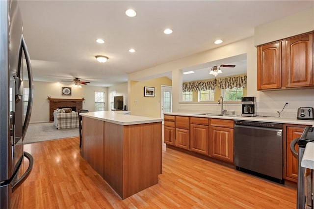 kitchen featuring plenty of natural light, appliances with stainless steel finishes, ceiling fan, a sink, and open floor plan