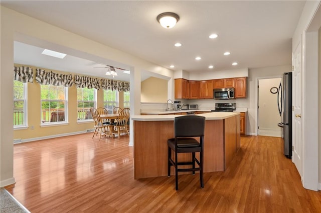 kitchen featuring stainless steel appliances, light countertops, light wood-style flooring, and recessed lighting