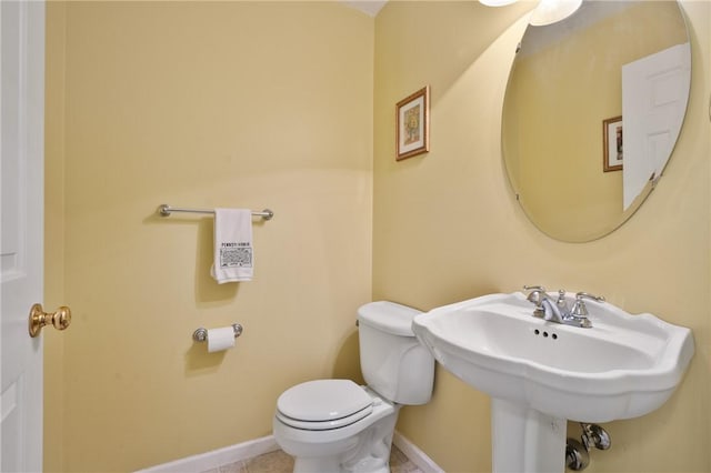 bathroom featuring toilet and baseboards