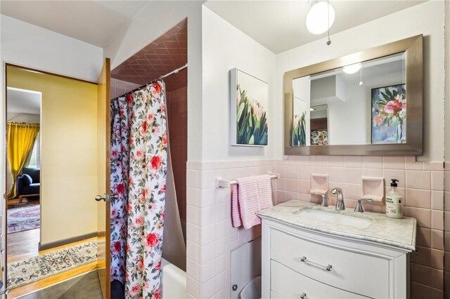 2364 Sheffield Rd, Aliquippa, PA 15001 - bathroom featuring shower / bath combo with shower curtain, tile walls, wainscoting, and vanity