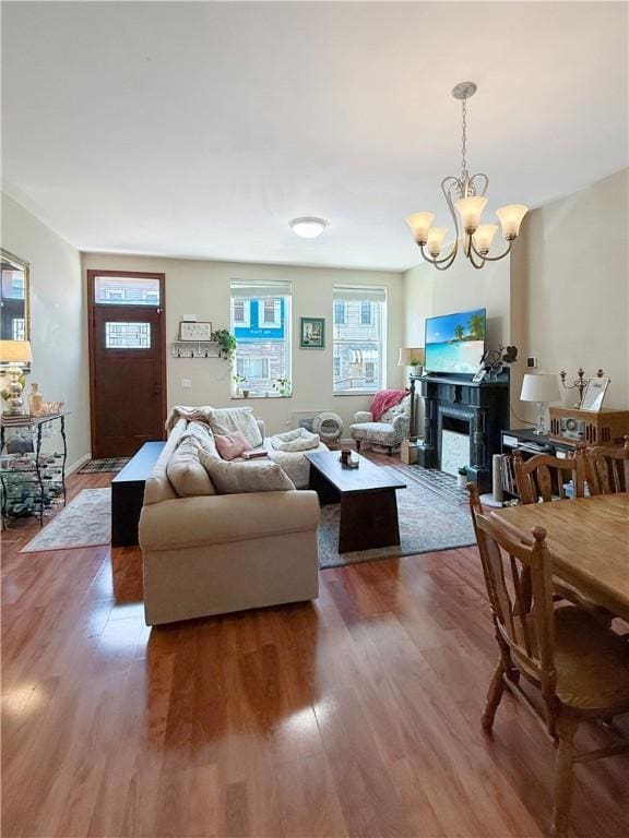 living room featuring a wealth of natural light, wood finished floors, and a notable chandelier