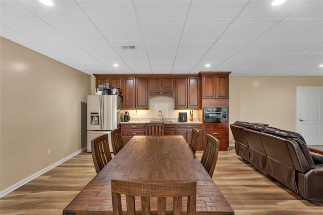 dining space with baseboards, visible vents, light wood finished floors, and recessed lighting