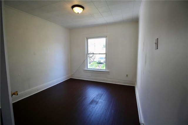 unfurnished room featuring dark wood-style floors and baseboards