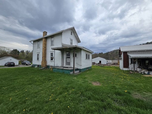 view of side of home with a lawn and a chimney