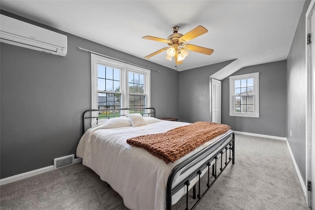 carpeted bedroom featuring baseboards, visible vents, multiple windows, and an AC wall unit