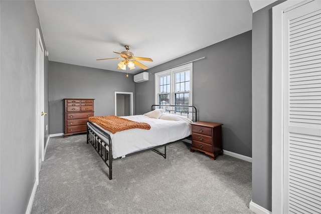 bedroom with carpet flooring, a wall mounted AC, a closet, ceiling fan, and baseboards