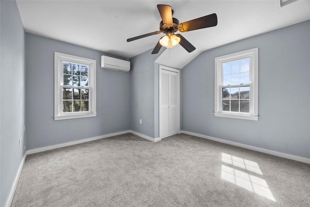 unfurnished bedroom with multiple windows, a closet, a wall mounted air conditioner, and carpet floors