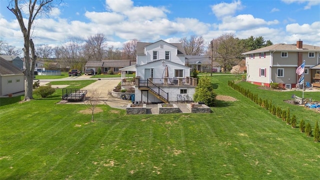 rear view of property with a wooden deck, a yard, and a residential view