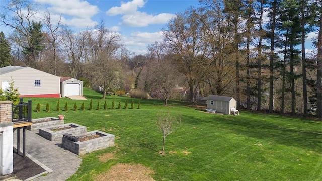view of yard featuring an outbuilding, a storage shed, a garden, and a garage