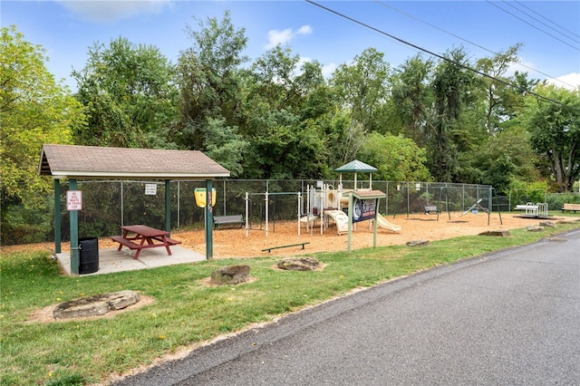 surrounding community with fence, playground community, and a lawn